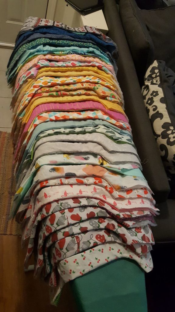 25 plus wine bags in partial construction laid side by side on an ironing board